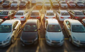 Image of a sunny car park full of post production cars